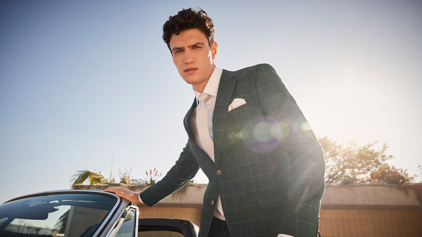 Model wearing POLITIX Spring Summer 2025 khaki windowpane check tailored suit – bold check tailoring refreshed for the new season.