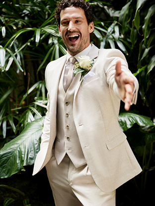 Groom wearing summer wedding suit pants and suit jacket.