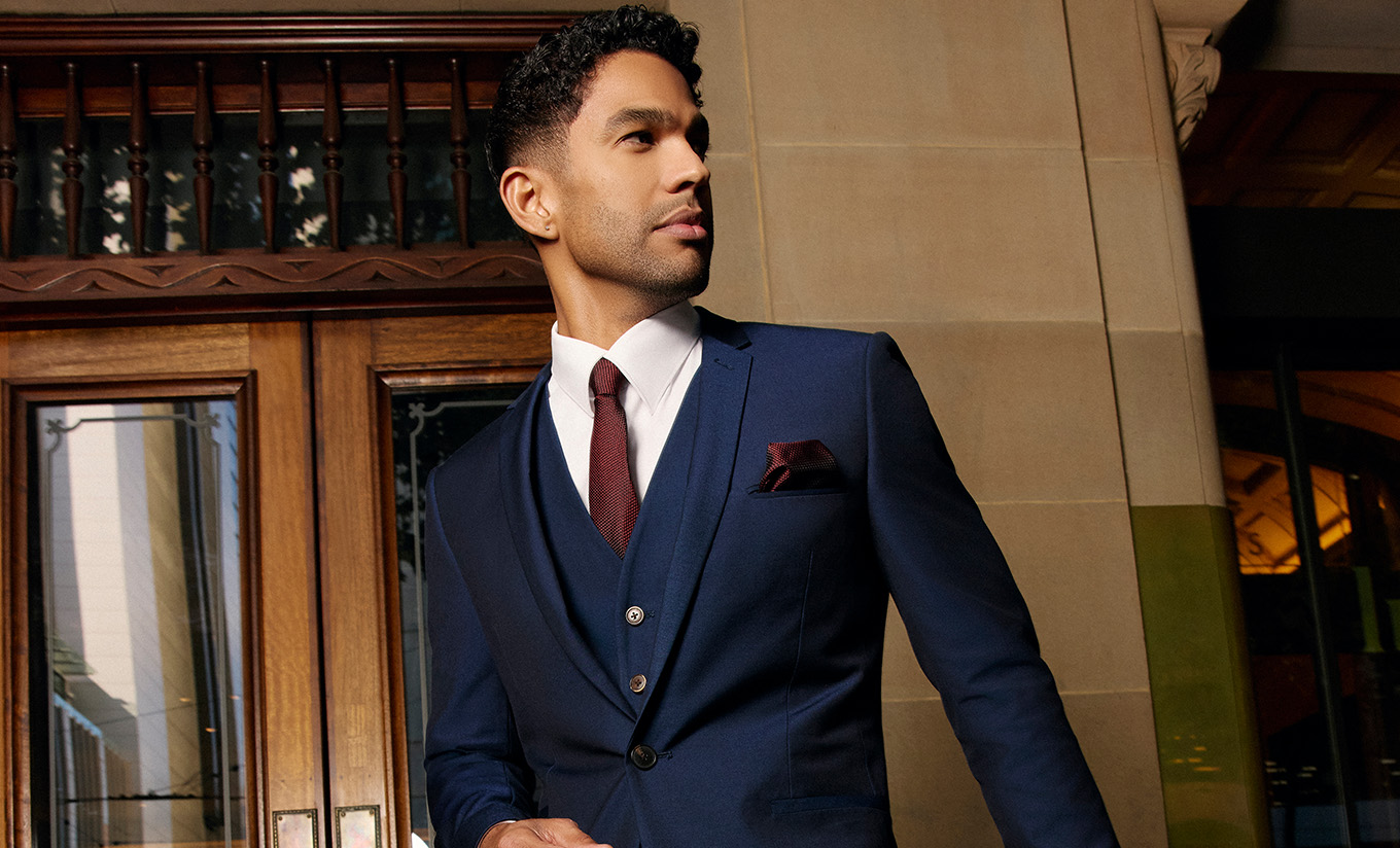 male walking in a stylish navy suit