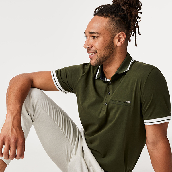 Model wearing a green polo short sleeve shirt