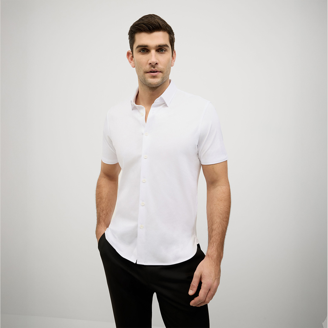 Man wearing a white short sleeve performance shirt with a clean tailored fit.