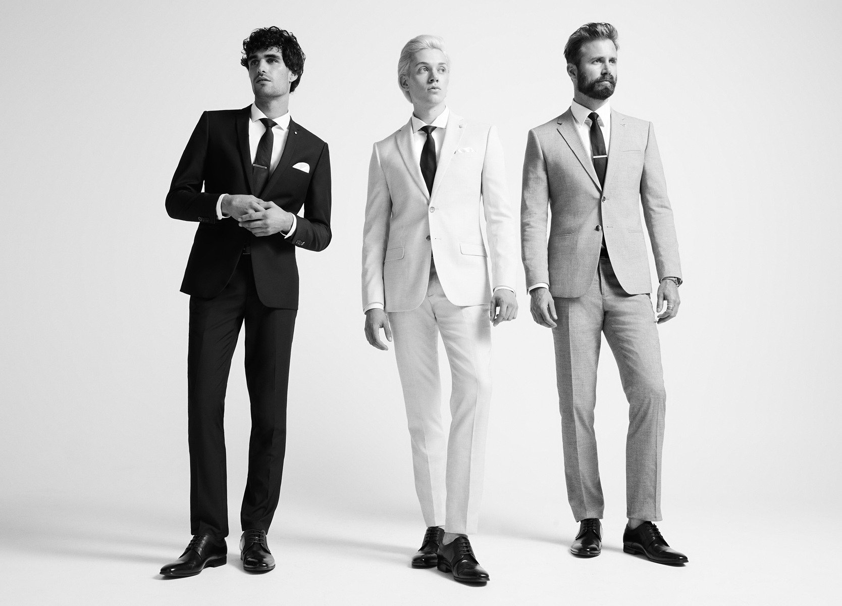 Fits For Anybody Black and white image of three different models wearing three different POLITIX fit suits