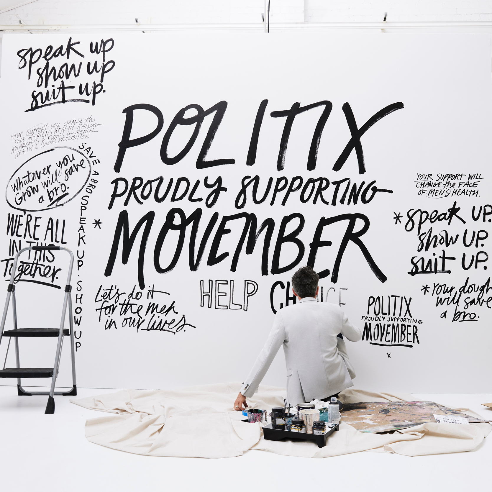 Nathan Johnson sitting in front of Movember artwork Nathan Johnson sitting in front of Movember artwork
